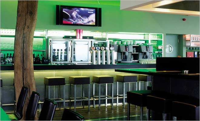 moderne bar met krukken en groene verlichting in hotel de pits in zolder