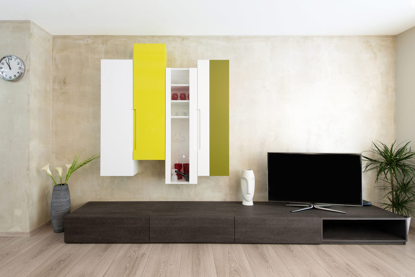 Laag tv-meubel op maat in hout in combinatie met wandkasten in felle kleuren